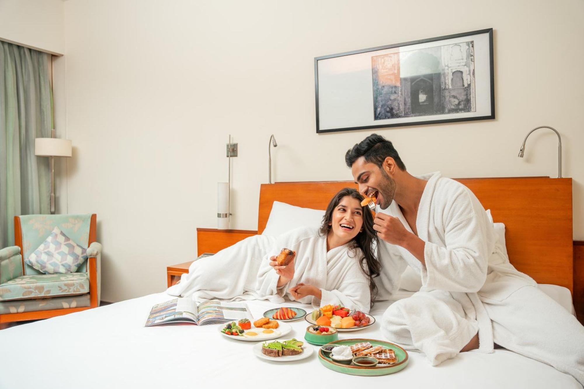 Hyatt Pune Exterior foto A couple eating breakfast in bed